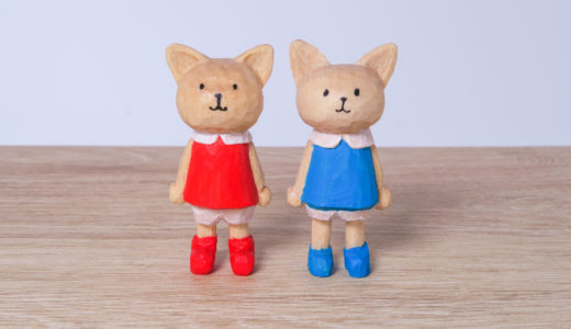木彫りの赤と青の服を着た猫さんズ