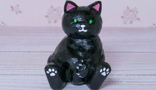 木彫りの尻尾を抱えた黒猫さん