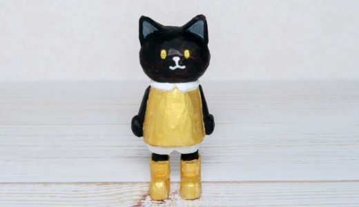 木彫りの金色服の黒猫さん